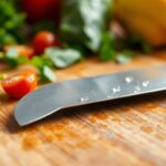 Knife on cutting board with vegetables around.